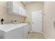 Bright laundry room featuring a washer, dryer, utility sink and built in storage cabinets at 1321 Eagles Flight Way, North Port, FL 34287