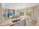 Open living space with view of pool area through large sliding glass doors and kitchen island at 1321 Eagles Flight Way, North Port, FL 34287