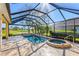 Screened lanai highlighting a spa, and a sparkling pool with a scenic view of lush landscaping at 1321 Eagles Flight Way, North Port, FL 34287