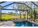 Screened lanai featuring a luxurious pool with a lovely water feature and a beautiful backyard at 1321 Eagles Flight Way, North Port, FL 34287