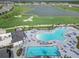 Aerial view showcasing a community pool area, golf course, and a serene lake at 15970 Grassland Ln # 2816, Punta Gorda, FL 33982