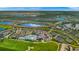 Aerial view of community amenities featuring a pool, clubhouse, tennis courts, and lush landscaping at 15970 Grassland Ln # 2816, Punta Gorda, FL 33982