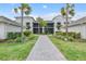 Beautiful building exterior, manicured landscaping, sidewalks, and palm trees at 15970 Grassland Ln # 2816, Punta Gorda, FL 33982