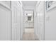 A well-lit hallway providing access to the bathroom with storage closets lining each side at 15970 Grassland Ln # 2816, Punta Gorda, FL 33982