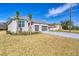 Charming single-story home with a manicured lawn, freshly laid gray brick driveway, and a three-car garage at 16579 Cape Horn Blvd, Punta Gorda, FL 33955