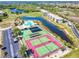 Aerial view showcasing the community's tennis courts, pool, lake and beautiful landscaping at 175 Kings Hwy # 232, Punta Gorda, FL 33983