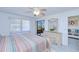 Bright bedroom with ceiling fan, balcony access, and dresser with decorative mirror at 175 Kings Hwy # 232, Punta Gorda, FL 33983