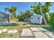 Picturesque backyard featuring a storage shed, fire pit, stone border, and lush landscaping at 21229 Giddings Ave, Port Charlotte, FL 33952