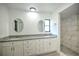 Primary bathroom boasts dual sinks with granite counters, white cabinets, oval mirrors, and a tiled walk-in shower at 21229 Giddings Ave, Port Charlotte, FL 33952