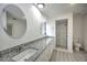 Bathroom with dual granite sinks, white cabinets, and walk-in shower at 21229 Giddings Ave, Port Charlotte, FL 33952