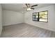 Bright living room featuring new flooring, ceiling fan, and a large window offering ample natural light at 21229 Giddings Ave, Port Charlotte, FL 33952