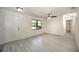 Bright, open living room featuring new flooring, a ceiling fan, and a front entry door at 21229 Giddings Ave, Port Charlotte, FL 33952