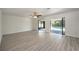 Bright, open living room with new floors, a ceiling fan, and sliding glass doors to the pool area at 21229 Giddings Ave, Port Charlotte, FL 33952