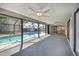 Spacious screened-in porch featuring a ceiling fan overlooking the pool and backyard at 21229 Giddings Ave, Port Charlotte, FL 33952