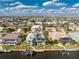 This aerial shot features a home with a boat dock and pool overlooking the calm water and nearby neighborhood at 2181 Via Seville, Punta Gorda, FL 33950