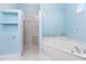 Well-lit bathroom with a tiled shower, bathtub, and seashell-themed decorations at 2181 Via Seville, Punta Gorda, FL 33950