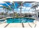 Screened-in pool with a view of the canal and tropical landscaping in backyard at 2181 Via Seville, Punta Gorda, FL 33950