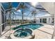 Screened-in pool and hot tub area surrounded by lush tropical landscaping and a canal view at 2181 Via Seville, Punta Gorda, FL 33950