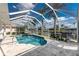 Sparkling blue pool is screened and overlooks lush tropical landscaping and canal at 2181 Via Seville, Punta Gorda, FL 33950
