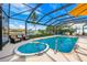 Screened-in pool area featuring a hot tub and comfortable seating, providing a luxurious outdoor experience at 2407 St Davids Island Ct, Punta Gorda, FL 33950