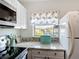 Charming kitchen with white cabinetry, marble counters, and bright window at 25050 Sandhill Blvd # B2 Building 6, Punta Gorda, FL 33983