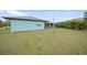 Large backyard featuring an expansive lawn, a fence line, and tropical landscaping at 25069 Bolivar Dr, Punta Gorda, FL 33983