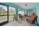 Bright sunroom with seating area, ceiling fan, and sliding glass doors, perfect for enjoying the outdoors indoors at 25069 Bolivar Dr, Punta Gorda, FL 33983