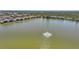 Aerial view of community lake, showcasing fountain and surrounding landscaping and residences at 25275 Rampart Blvd # 1602, Punta Gorda, FL 33983