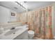 Bright bathroom featuring a single sink vanity with marble countertop and patterned shower curtain at 25275 Rampart Blvd # 1602, Punta Gorda, FL 33983