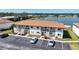 Condominium complex offering a lake view, lush greenery, and ample parking for residents and guests at 25275 Rampart Blvd # 1602, Punta Gorda, FL 33983