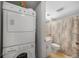 Convenient laundry area with a stacked washer and dryer set next to the bathroom at 25275 Rampart Blvd # 1602, Punta Gorda, FL 33983