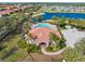 Aerial view of the community clubhouse with a pool, lake, and surrounding homes at 3860 Cobblestone Ln, Punta Gorda, FL 33980