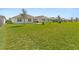 Grassy backyard featuring a covered patio, manicured lawn, and surrounding properties at 3860 Cobblestone Ln, Punta Gorda, FL 33980