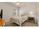 Bright bedroom features floral bedding, white metal frame, ceiling fan and natural light at 3860 Cobblestone Ln, Punta Gorda, FL 33980
