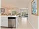 Open-concept kitchen with breakfast bar, stainless steel dishwasher, and view into the living room at 3860 Cobblestone Ln, Punta Gorda, FL 33980
