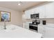 Contemporary kitchen featuring white cabinets, quartz countertops, and stainless steel appliances at 3860 Cobblestone Ln, Punta Gorda, FL 33980