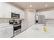 Bright, modern kitchen with white cabinetry, stainless steel appliances, and quartz countertops at 3860 Cobblestone Ln, Punta Gorda, FL 33980
