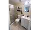 Bright bathroom featuring a glass shower enclosure, white vanity, and tiled floors at 4045 Conway Blvd, Port Charlotte, FL 33952