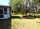Spacious backyard featuring mature trees and lush green grass at 5098 Adina Cir, North Port, FL 34291