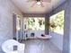 Enclosed porch with tiled floor, ceiling fan, and views of the lush landscaping at 5098 Adina Cir, North Port, FL 34291