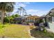 Green backyard with a large pool area, enclosed screen, and a built in BBQ at 5126 Richmond Ter, North Port, FL 34287
