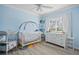 Light blue baby room with hardwood floors, a large dresser, and a crib at 5126 Richmond Ter, North Port, FL 34287