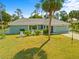 Well-maintained single-story home with tidy front lawn, palm trees, and an attached garage at 5126 Richmond Ter, North Port, FL 34287