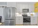 Updated kitchen featuring stainless steel refrigerator, range, microwave, and white cabinetry at 5126 Richmond Ter, North Port, FL 34287
