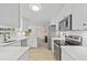 Modern kitchen with stainless steel appliances, white cabinets, and quartz countertops at 5126 Richmond Ter, North Port, FL 34287