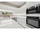 Modern kitchen featuring stainless steel appliances and sleek white cabinetry at 5636 Barlow Ter, North Port, FL 34287