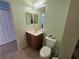 This well-lit bathroom features a tile floor, toilet and vanity with a sink at 5746 Douglas Rd, North Port, FL 34288