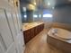 Main bathroom with tiled floors, a tub, a vanity with double sinks, and half moon window accents at 5746 Douglas Rd, North Port, FL 34288