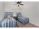Cozy bedroom featuring two twin beds with blue accents and a ceiling fan at 7304 W Lenox Circle, Punta Gorda, FL 33950