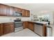 Kitchen area featuring stainless appliances, dark cabinetry, and access to living area at 7304 W Lenox Circle, Punta Gorda, FL 33950